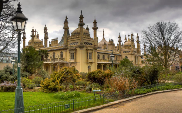 Man-made Royal Pavilion with ornate spires, gardens and a lamppost under a moody sky — 2K Quad HD PC desktop wallpaper/background.