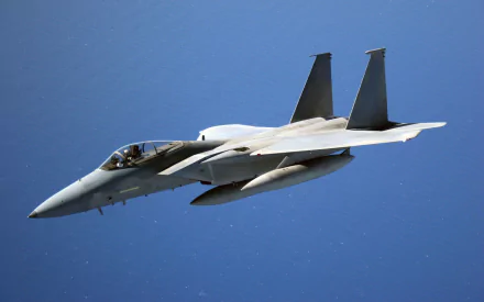 HD desktop wallpaper featuring a McDonnell Douglas F-15 Eagle military jet soaring against a clear blue sky.