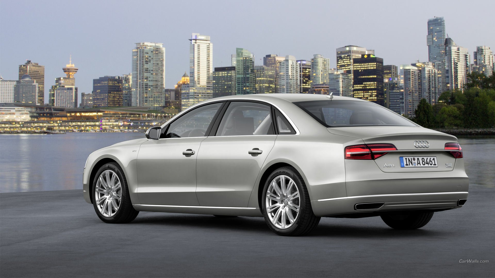 A sleek Audi A8 L parked against a city skyline, showcasing its luxury design. This high-definition wallpaper captures the elegance of the Audi A8 in a stunning urban setting.