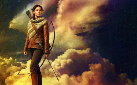 Katniss Everdeen stands confidently with a crossbow against a dramatic sky, showcasing her strength from *The Hunger Games: Catching Fire* in this striking HD desktop wallpaper.