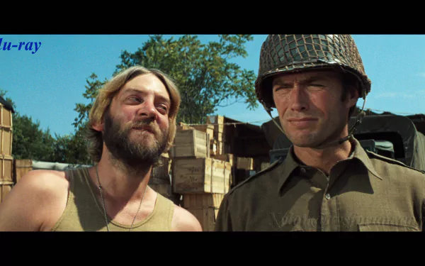 HD PC desktop wallpaper background from the movie Kelly's Heroes: two WWII soldiers—a bearded man smiling and a helmeted soldier—stand before stacked wooden crates under a blue sky.
