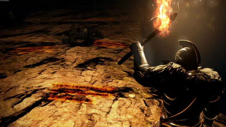 HD PC desktop wallpaper from the video game Dark Souls II, showing a cloaked knight holding a torch illuminating a dark, rocky cavern.