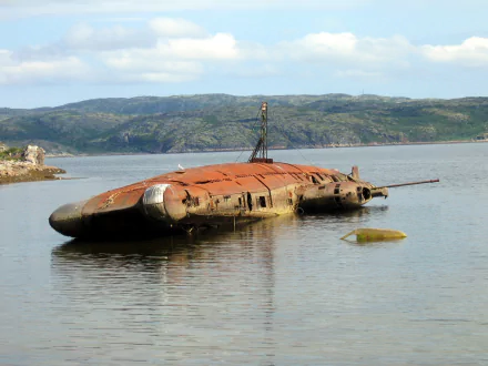 HD PC desktop wallpaper: rusted submarine-like vehicle wreck partially submerged in calm coastal waters, distant green hills under a cloudy sky.