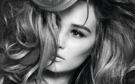 Black-and-white close-up of a woman with voluminous hair and a pensive gaze; identity not provided. HD PC desktop wallpaper/background.