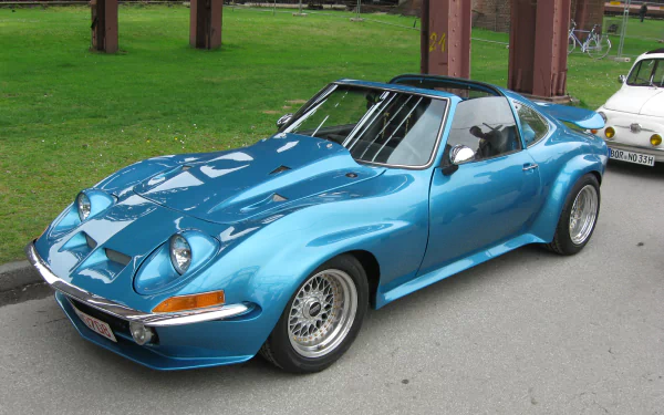 Shiny blue Opel GT sports car parked on pavement, captured as a 2K Quad HD PC desktop wallpaper and background.