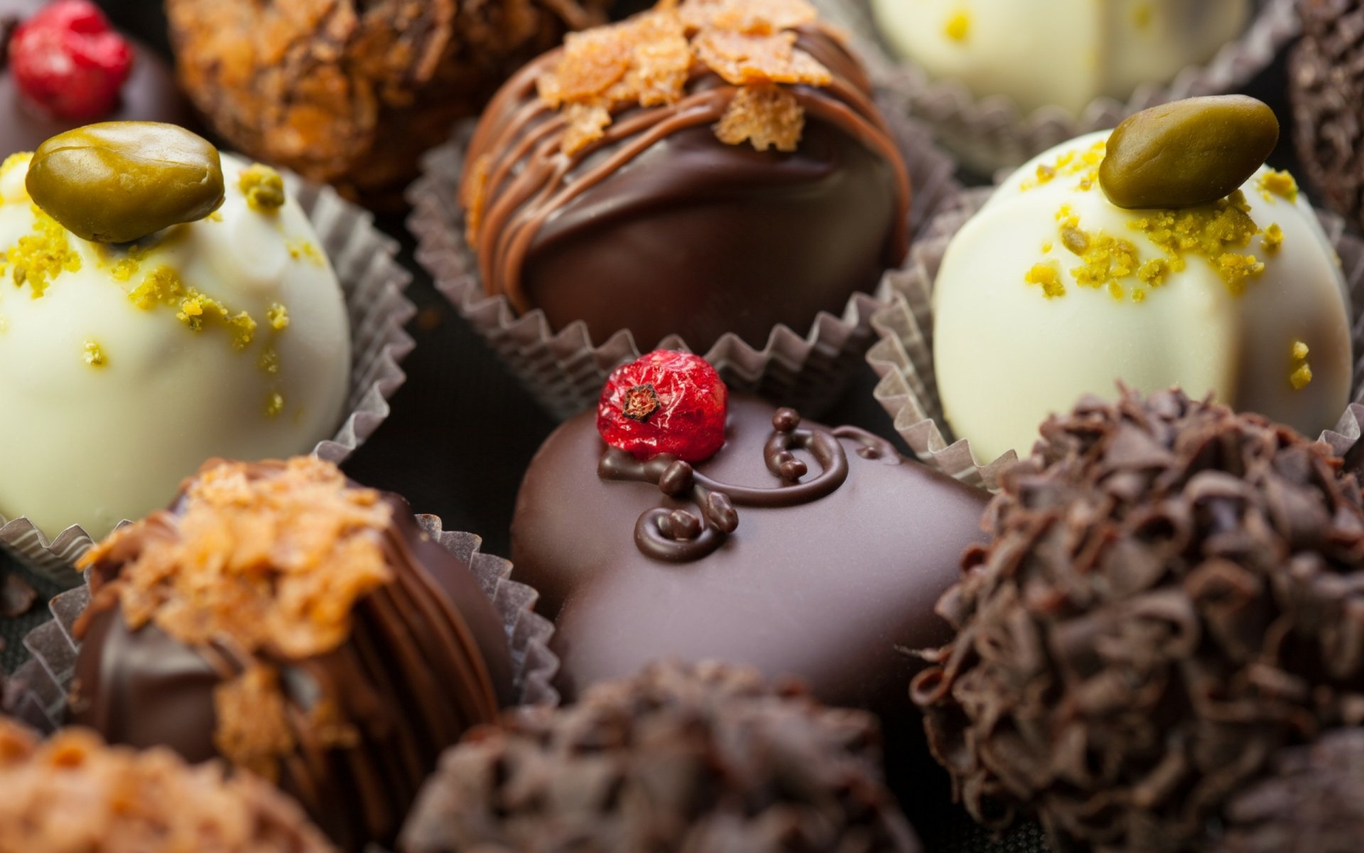 HD desktop wallpaper showcasing an assortment of gourmet chocolates with various toppings and textures, highlighting rich food and chocolate details.