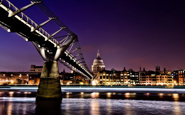 Man-made Millennium Bridge at dusk crossing the Thames toward illuminated St. Paul's Cathedral under a vibrant night sky — 2K Quad HD PC desktop wallpaper/background.