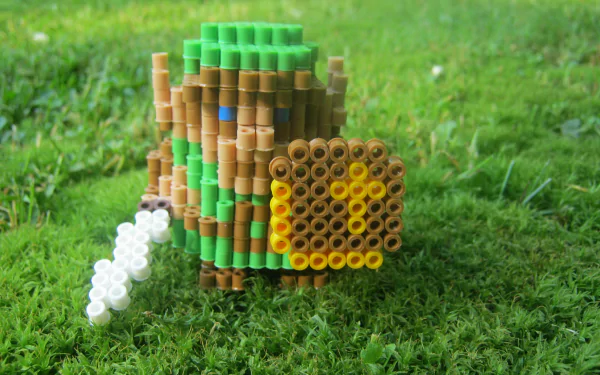 HD PC desktop wallpaper featuring a pixelated The Legend of Zelda character crafted from colorful beads on a grassy background.