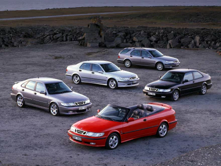 HD PC desktop wallpaper/background showing five Saab vehicles — a red convertible in front with four silver/gray sedans/hatchbacks on a gravel lot and rocky backdrop.
