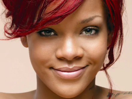 High-definition desktop wallpaper featuring a close-up of Rihanna, showcasing her vibrant red hair and captivating smile against a neutral background.