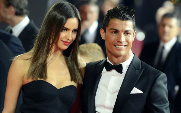 HD wallpaper featuring Irina Shayk and Cristiano Ronaldo at a formal event. Both are elegantly dressed, with Shayk in a strapless black dress and Ronaldo in a black tuxedo. Tags: Sports.