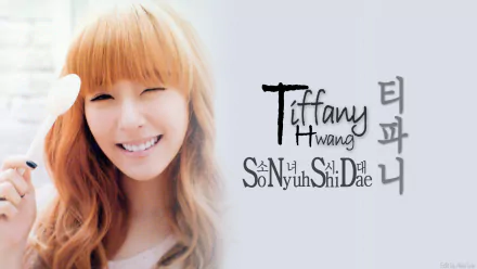 HD PC wallpaper of a smiling Korean K-pop singer with long auburn hair, soft pastel background, and stylized English and Korean typography referencing her name and group.