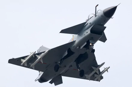 Military Chengdu J-10 fighter jet viewed from below with missiles against pale sky; HD PC desktop wallpaper/background.