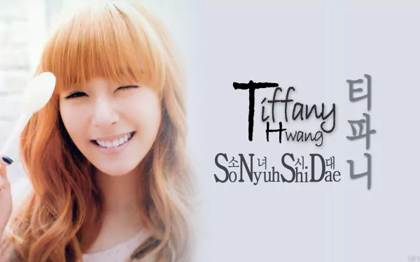 HD PC wallpaper of a smiling Korean K-pop singer with long auburn hair, soft pastel background, and stylized English and Korean typography referencing her name and group.