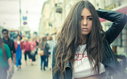 HD PC desktop wallpaper featuring a woman with long hair, wearing a leather jacket and white shirt, walking down a busy street, tagged Diana Melison.
