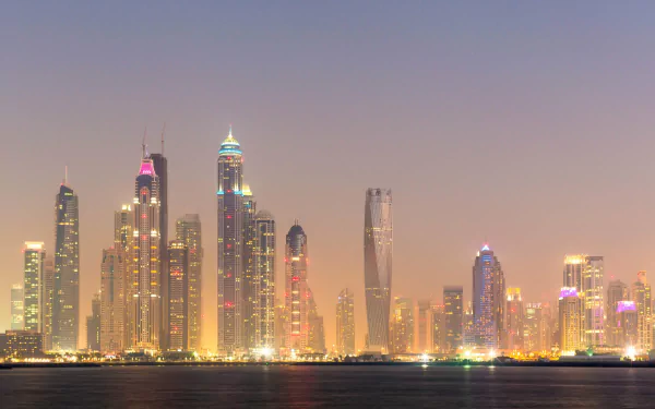 A stunning HD wallpaper showcasing Dubai's iconic skyline at dusk, featuring illuminated skyscrapers that reflect the city's modern architecture and vibrant atmosphere.