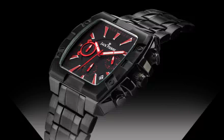 HD desktop wallpaper featuring a sleek, black Jack Pierre man-made watch with red accents on the dial, highlighted against a gradient dark background.