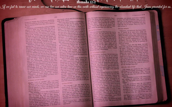 An HD desktop wallpaper featuring an open Christian Bible with highlighted text, set against a wooden background. The top features scriptural text from Romans 12:2.