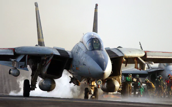 HD desktop wallpaper showing a military Grumman F-14 Tomcat fighter jet on a runway with crew members in the background preparing for takeoff.