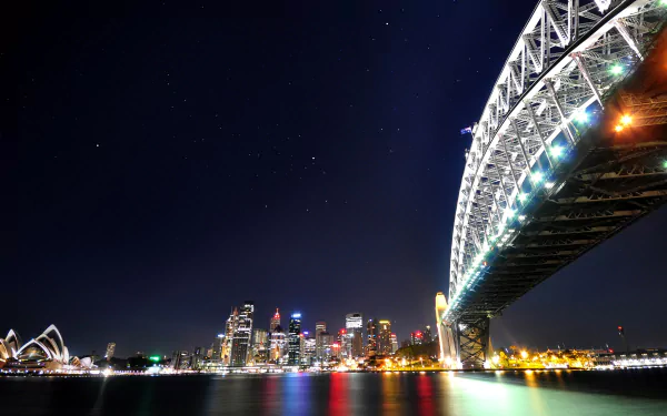 Night view of Sydney Harbour Bridge and Sydney Opera House illuminated against the city skyline in Australia, captured in stunning 4K Ultra HD.