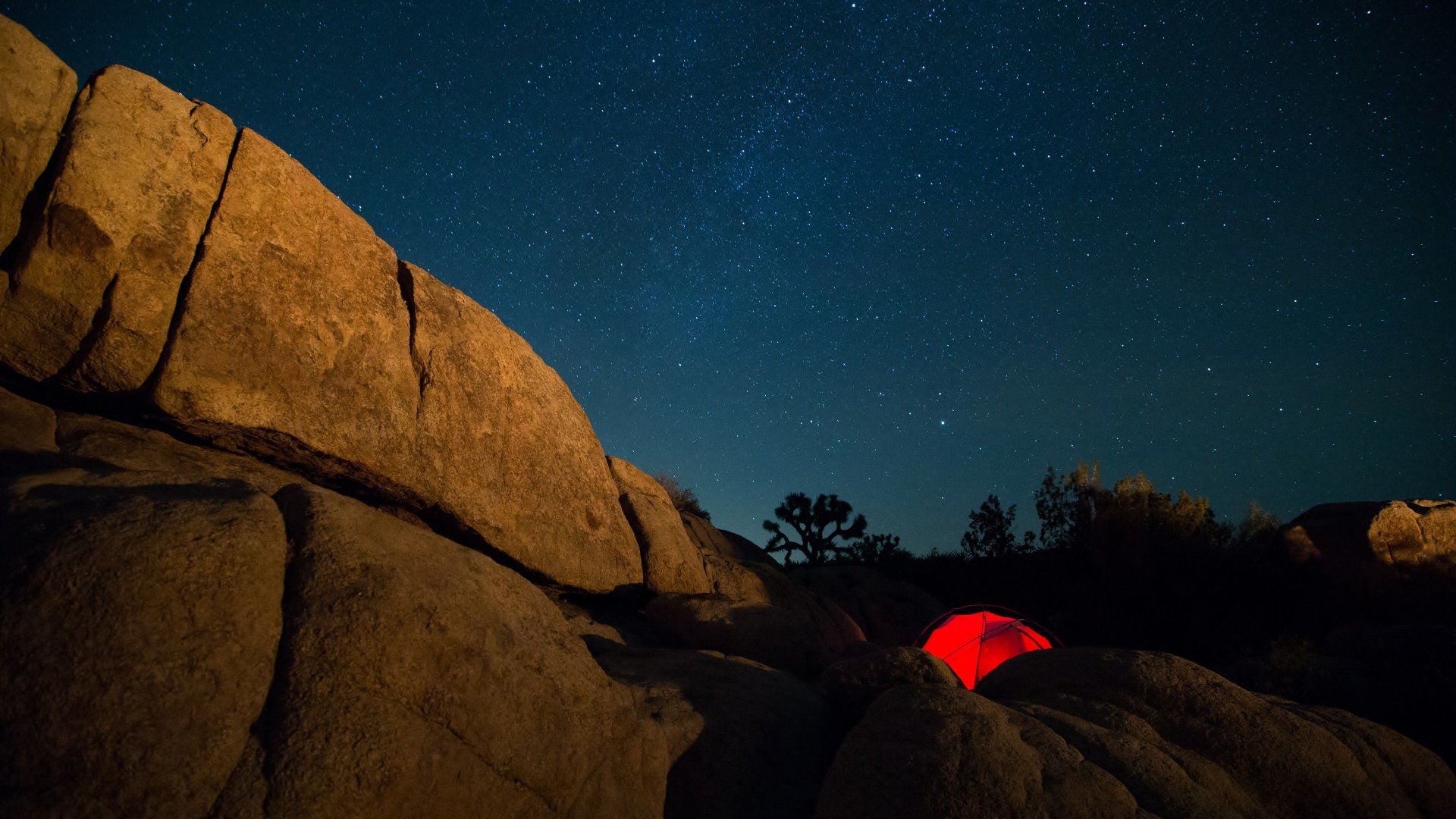 4K Ultra HD sci-fi inspired PC desktop wallpaper showing a glowing red tent nestled among large rocks under a star-filled night sky.