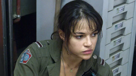 HD desktop wallpaper featuring Michelle Rodriguez in a scene from the movie Avatar, showing her in military attire with a pensive expression.