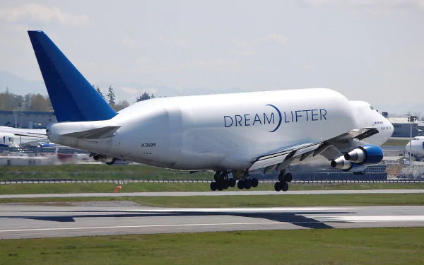 Boeing 747 Dreamlifter cargo vehicle touching down on runway, Dreamlifter livery visible — 2K Quad HD PC desktop wallpaper background.