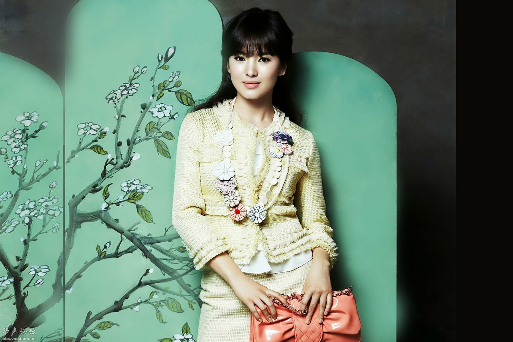Korean actress Song Hye Kyo poses elegantly against a backdrop of floral designs in this HD desktop wallpaper, showcasing her beauty and style.