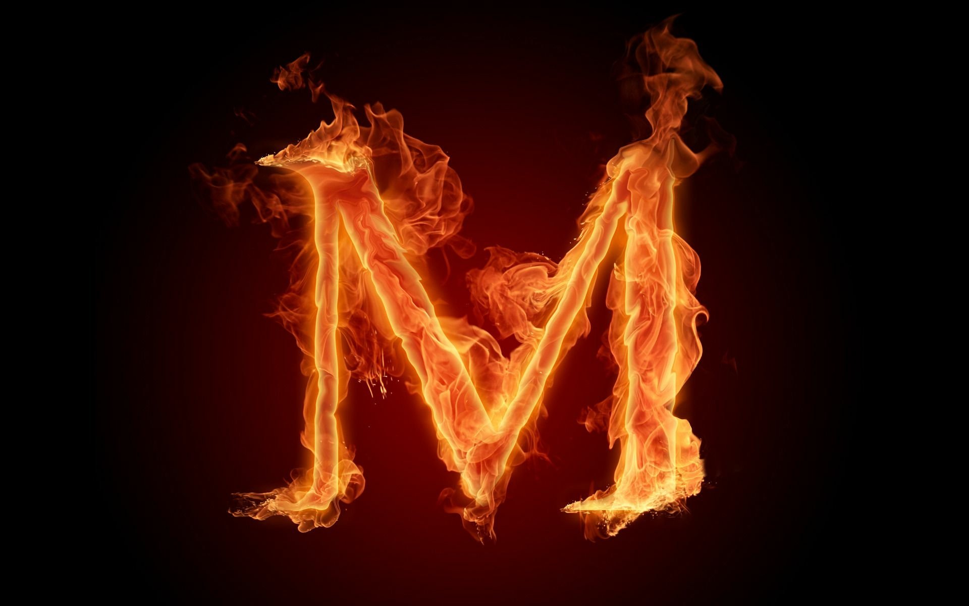 Artistic HD PC desktop wallpaper featuring a bold letter M engulfed in vivid, dynamic flames against a dark background.