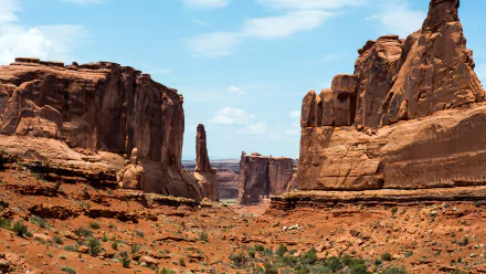 Arches National Park landscape featuring towering red rock formations under a partly cloudy sky, captured in stunning 4K Ultra HD for a PC desktop wallpaper.