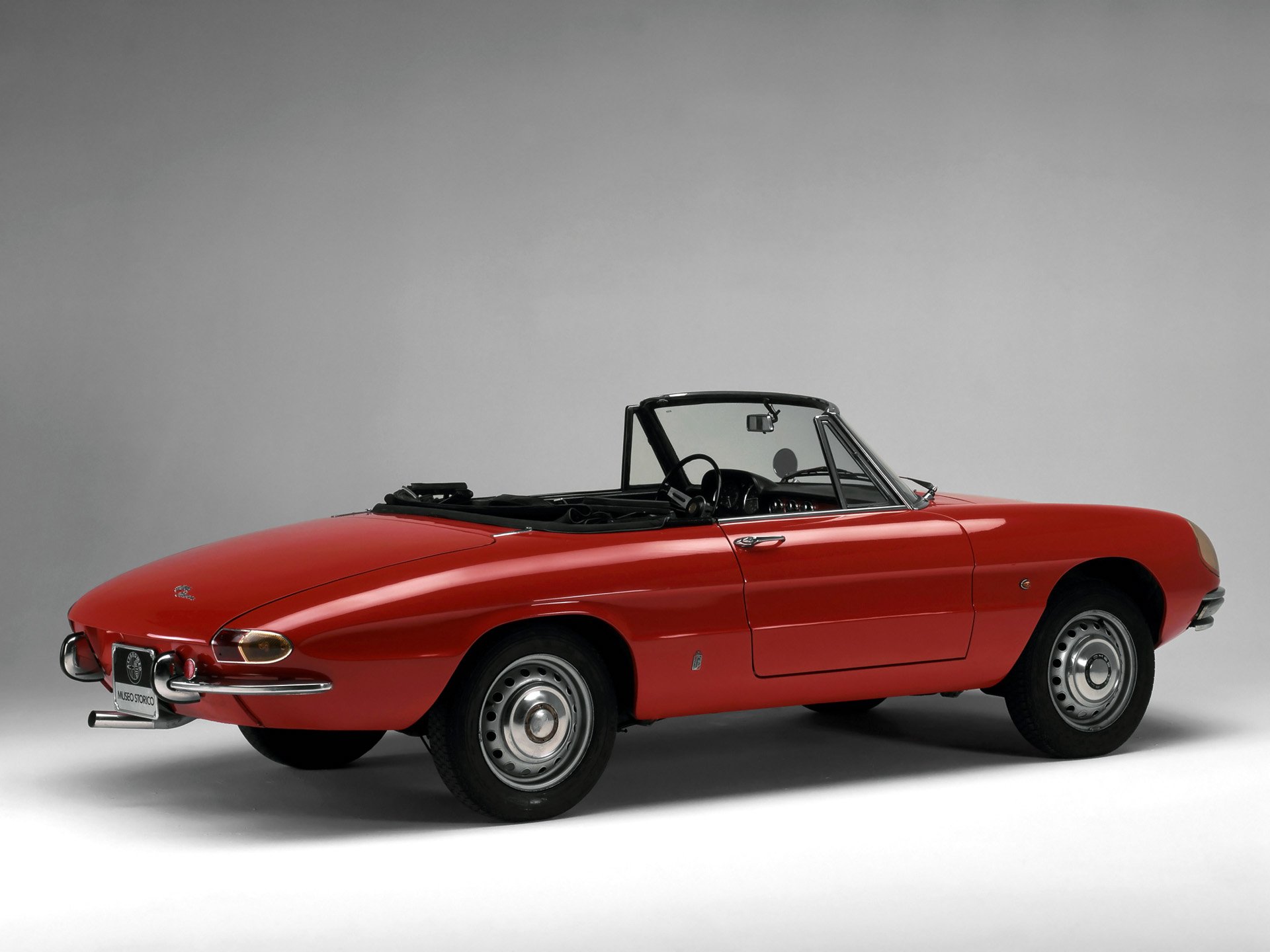 HD PC desktop wallpaper of a red Alfa Romeo Spider convertible vehicle against a plain light gray background.