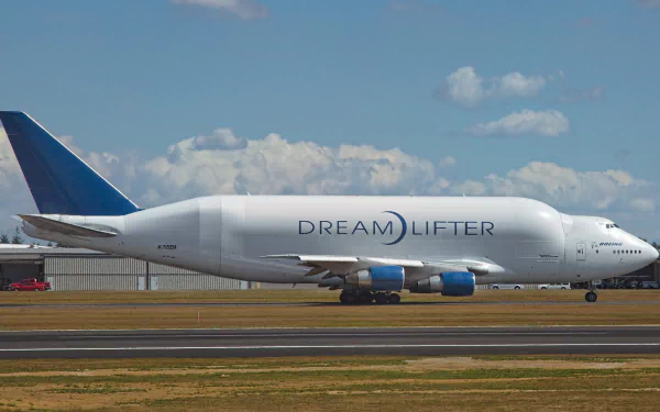 Boeing 747 Dreamlifter airplane on a runway under a partly cloudy sky, captured in an HD PC desktop wallpaper background.