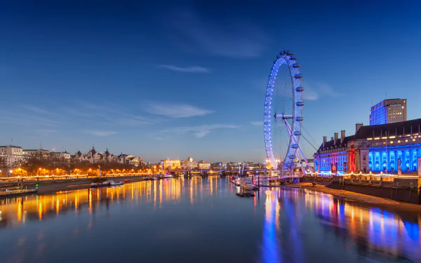 A stunning view of the London Eye illuminated at night, reflecting in the river, showcasing the vibrant lights of the surrounding buildings in a picturesque urban scene.