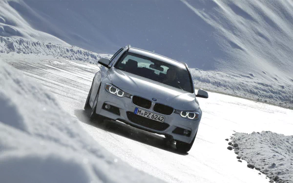 Silver 2013 BMW 320d carving through a snowy mountain pass — high-definition PC desktop wallpaper and background.