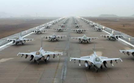 HD wallpaper of multiple General Dynamics F-16 Fighting Falcon aircraft lined up on a runway.