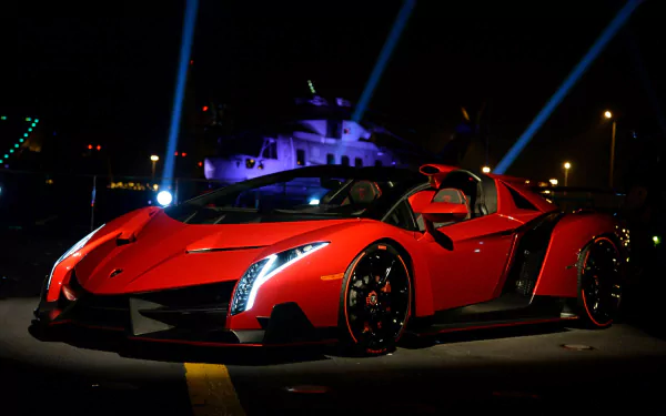 A striking red Lamborghini Veneno Roadster showcased at night, illuminated by vibrant lights, creating a stunning HD desktop wallpaper and background.