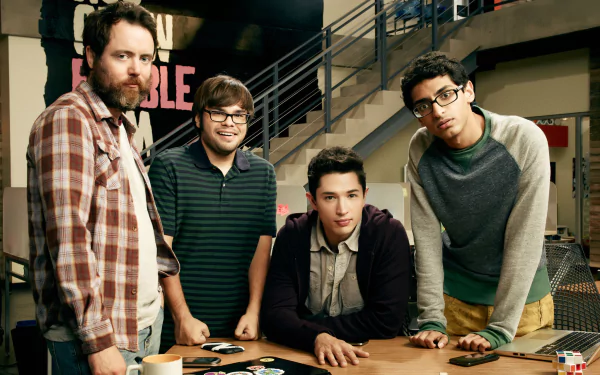 HD desktop wallpaper featuring a group of four men from the show Betas, standing in an office environment.