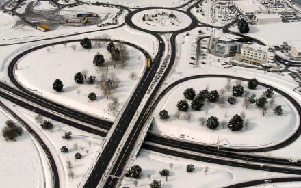 HD PC desktop wallpaper and background: aerial view of a snow-covered, man-made highway interchange with roundabouts, trees and buildings in Saint-Malo.