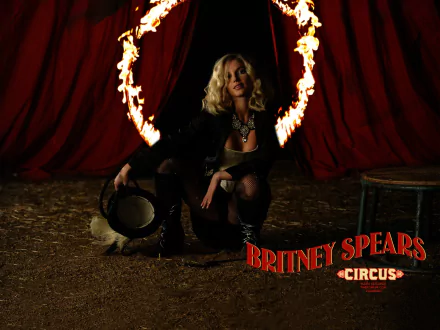 HD PC desktop wallpaper featuring Britney Spears in a circus-themed music setting with fiery hoop and dramatic red curtains in the background.