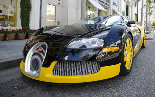 A sleek black and yellow Bugatti Veyron parked on a city street, captured in stunning 4K Ultra HD for a PC desktop wallpaper.