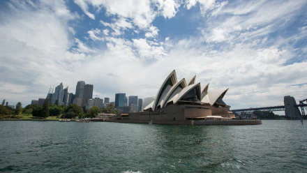 4K Ultra HD PC desktop wallpaper: Sydney Opera House, man-made shell-like sails on Sydney Harbour with city skyline, Australia.