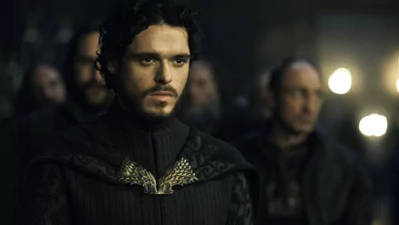 Richard Madden as Robb Stark in this HD Game of Thrones wallpaper captures a moment of intensity, showcasing his character's determination amidst a backdrop of intriguing tension.