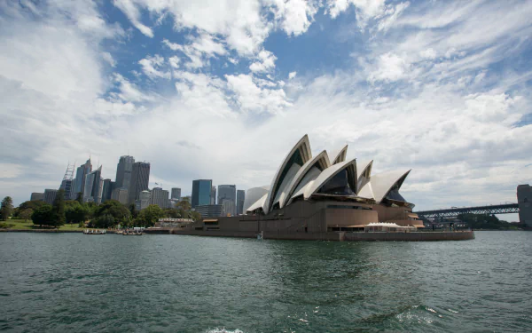 4K Ultra HD PC desktop wallpaper: Sydney Opera House, man-made shell-like sails on Sydney Harbour with city skyline, Australia.