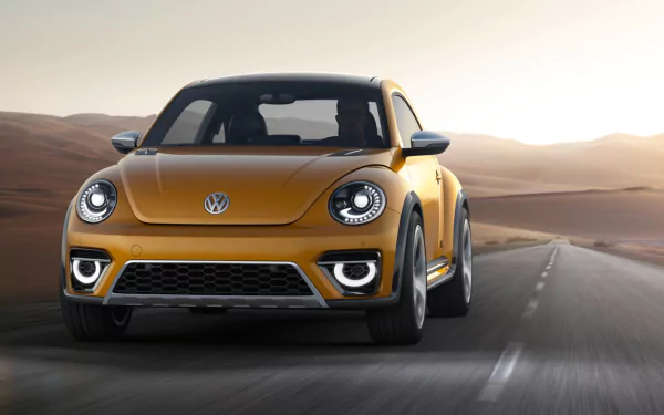 Front three-quarter view of a golden 2014 Volkswagen Beetle Dune Concept vehicle driving on a desert road at sunset — HD PC desktop wallpaper.
