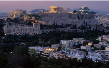 HD desktop wallpaper showcasing the ancient Acropolis of Athens illuminated at dusk, highlighting the blend of historic man-made structures and the modern cityscape.
