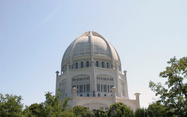 HD desktop wallpaper featuring the white dome of a Baha'i Temple surrounded by greenery under a clear sky, highlighting its religious architecture.