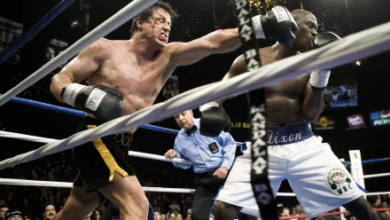 HD wallpaper of a scene from Rocky featuring Sylvester Stallone as Rocky Balboa in a boxing match, throwing a punch.