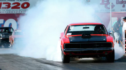 A striking Dodge Charger races down the track, surrounded by a cloud of smoke, showcasing its powerful presence in this vibrant 8K Ultra HD PC desktop wallpaper.