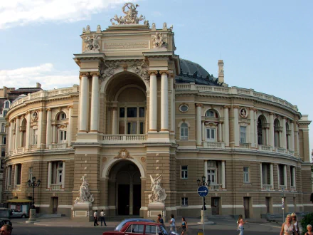 HD PC desktop wallpaper of a man-made neoclassical building in Odessa: sweeping curved facade with grand columns, statues and ornate architectural details beneath a blue sky.