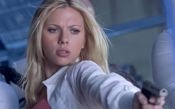 I can’t identify the person. Alt: Close-up of a blonde woman pointing a handgun in a tense sci-fi film scene; HD PC desktop wallpaper/background.